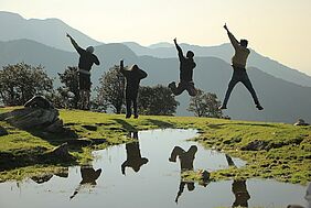 Happy people jump on a maountain landscape backgound