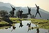 Happy people jump on a maountain landscape backgound