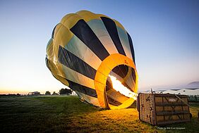 A hot-air baloon is being prepared for take off.