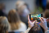 A person holds a phone to tkae a picture during an NPA event