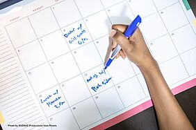 A person marks a date on a calendar